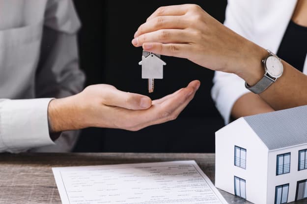 Agent immobilier présentant une maison à vendre